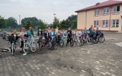 dzieci z rowerami na tle szkoly