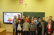Młodzi uczniowie pozujący na sali w strojach karnawałowych 