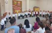 Dzieci z gr. I  w opaskach misiach stoja  przed rodzicami.