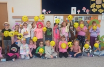 Dzieci z balonami na ktorych narysowane sa usmiechniete buzie