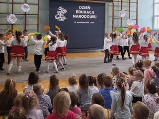 Dzieci tancza w kolach z listkami.