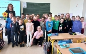 Zdjecie szesciolatkow z p. nauczycielka na tle tablicy szkolnej.